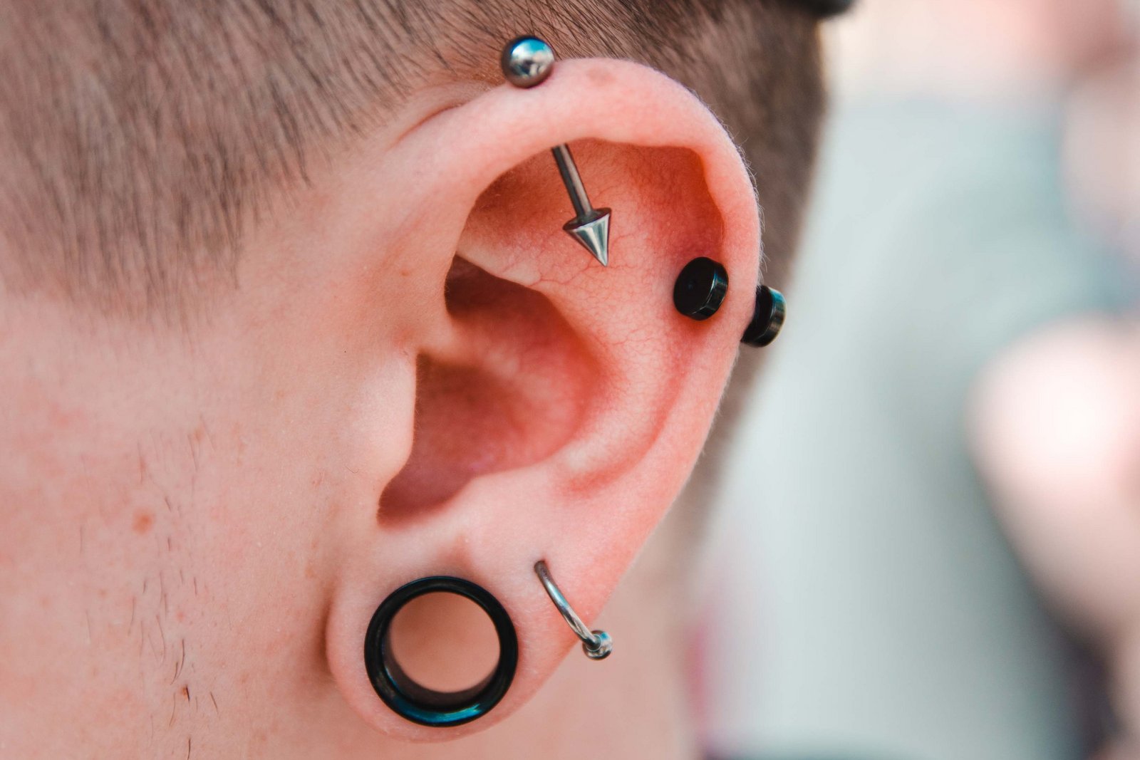 Man met veel piercings in zijn oor