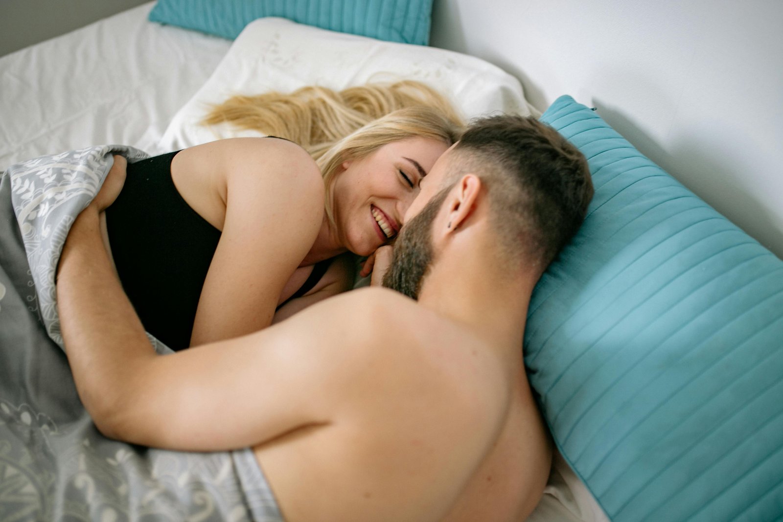 Man en vrouw knuffelen in bed als wellnessprogramma